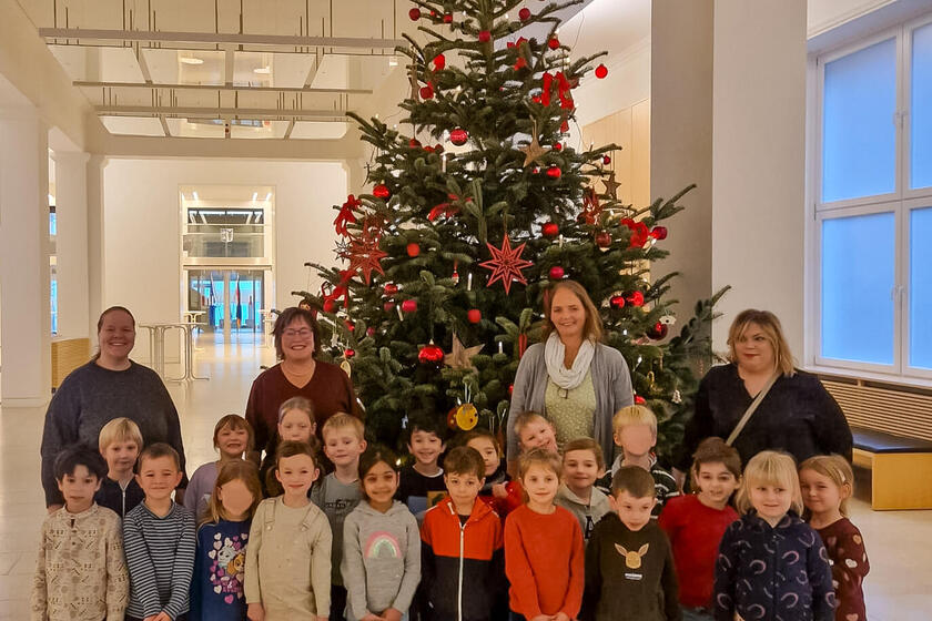 Gruppenfoto mit 20 Kindern, drei Erzieherinnen und Eka von Kalben vor dem Weihnachtsbaum im Kieler Landtag.