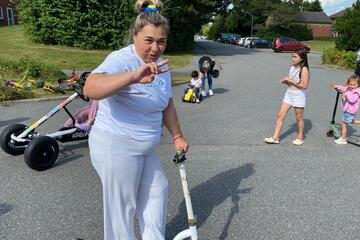 Junge Frau auf Roller zum Treten