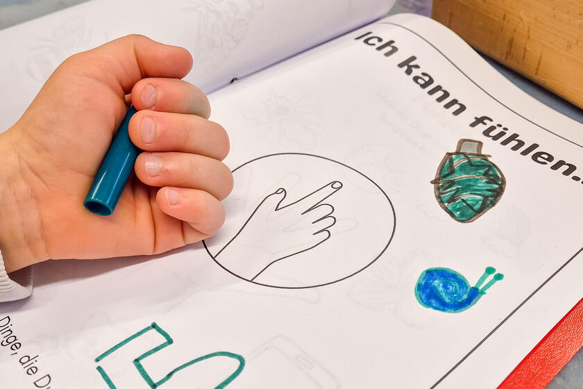 Auf einem Tisch liegt ein Heft mit einem Arbeitsblatt zum Thema "Ich kann fühlen".