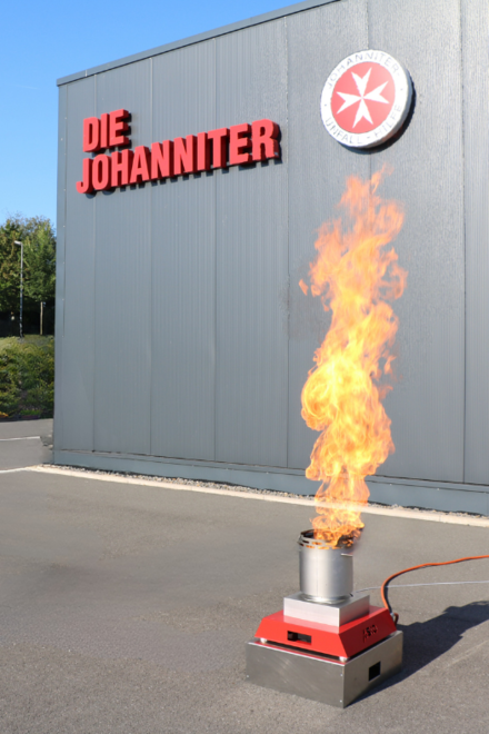 Ein kontrolliertes Feuer im Rahmen einer Ausbildungssituation zum Brandschutzhelfenden. Die Feueranlage steht unter freiem Himmel vor der Regionalgeschäftsstelle der Johanniter Lippe-Höxter in Blomberg. 