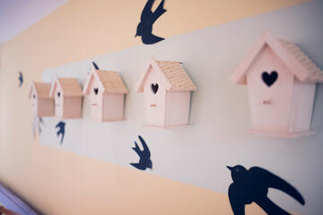 Ein Reihe kleiner Vogelhäuschen als Wandgestaltung