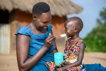 Amin füttert ihre Tochter mit Brei