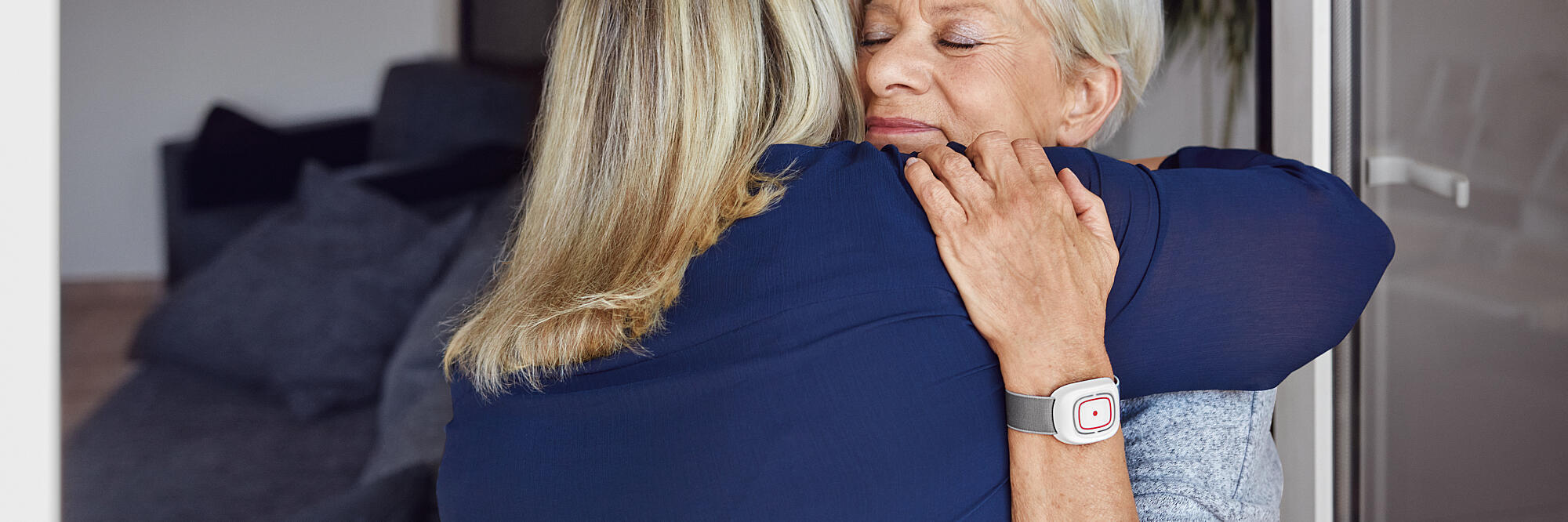 Eine Kundin des Hausnotruf umarmt eine Johanniter-Mitarbeiterin