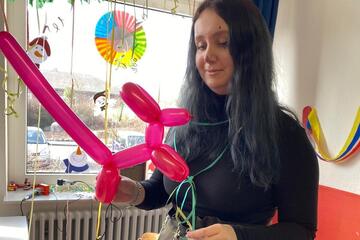 Eine Mitarbeiterin fo9rm Luftballontiere