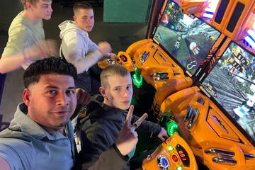 Mehrere Jugendliche spielen an den Spielgeräten, mit auf dem Foto der Betreuer.