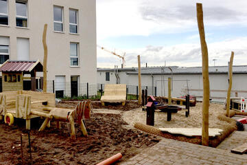 Spielpferd und weitere Holzspielgeräte des Außenbereiches der Kita am Wieter.