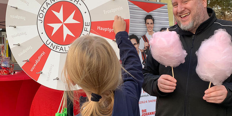 Ein Mitarbeiter verteilt Zuckerwatte auf dem Schängelmarkt 2022