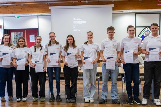 Personengruppe Schülerinnen und Schüler mit Urkunden in den Händen