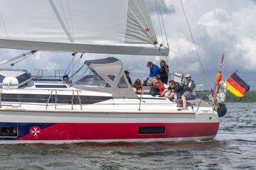 Crew auf dem Segelboot der Johanniter setzt die Segel.
