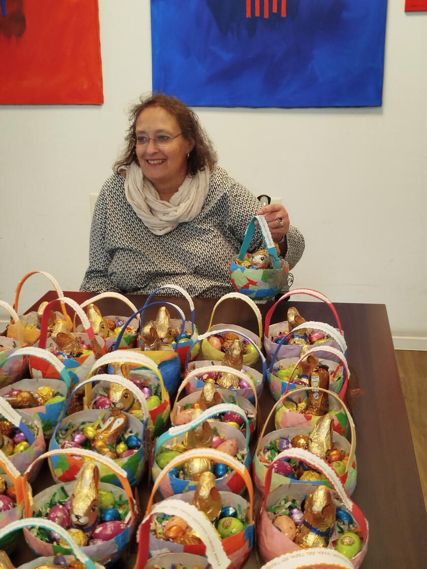 Frau vor einem Tisch mit gefüllten Osterkörben 