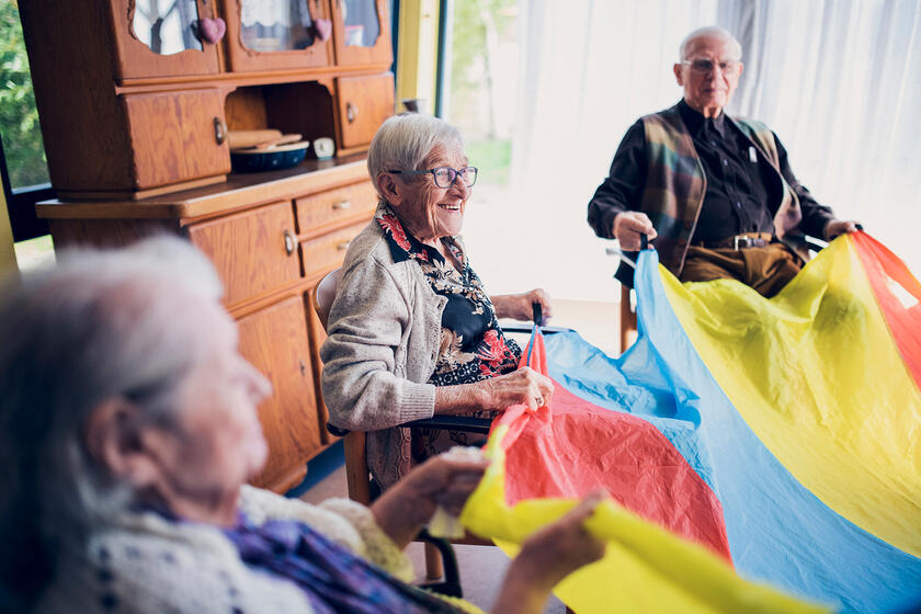 Bewohnende halten ein buntes Schwungtuch in den Händen