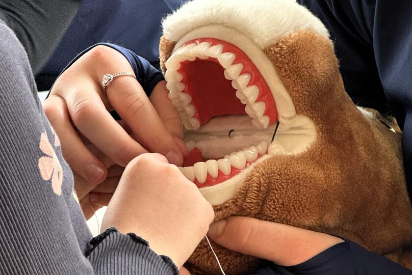 Zahnarztteam zeigt den Kindern wie man Zahnseide benutzt