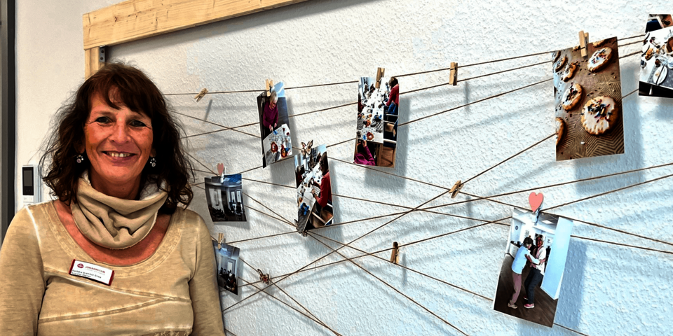 Eine Frau steht vor einer Wand mit Fotos.