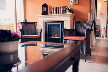 Aufenthaltsraum mit Elektrokamin und 2 Korbstühle im Johanniter-Haus Mutter Eva von Tiele-Winckler in Wentorf.