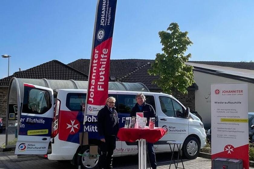 Zwei Mitarbeitende der Johanniter-Fluthilfe informieren am Stand der Infobustour