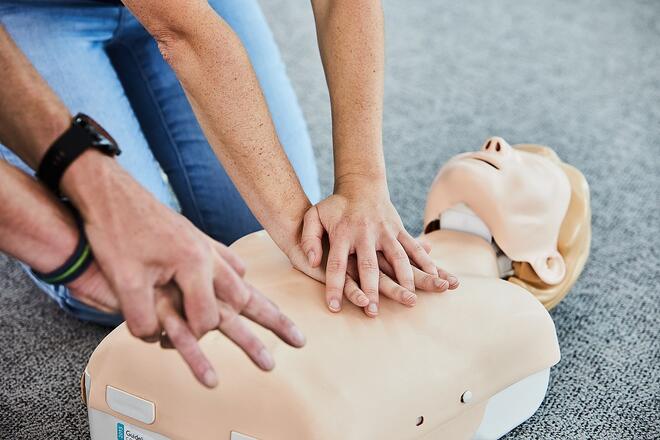 Ein Teilnehmer des Erste Hilfe Kurses bekommt die Herz-Druck-Massage gezeigt