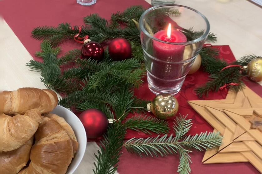 Stillleben weihnachtlicher Tischschmuck mit Kerze und Croissants
