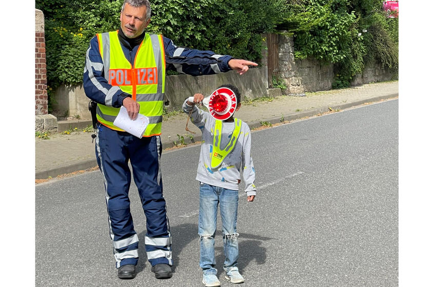 Ein Polizist mit einem Kind, das eine Polizeikelle hält