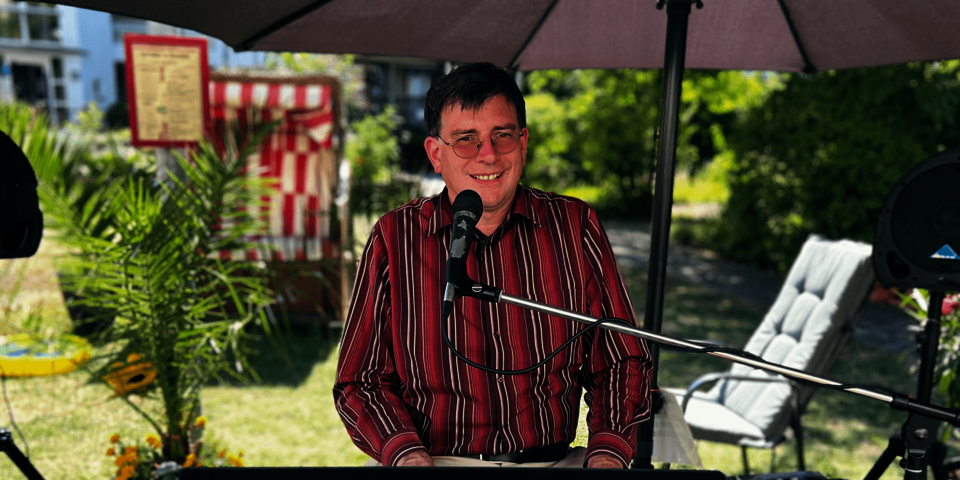 Ein Mann in einem gestreiften Hemd an einem Keyboard 