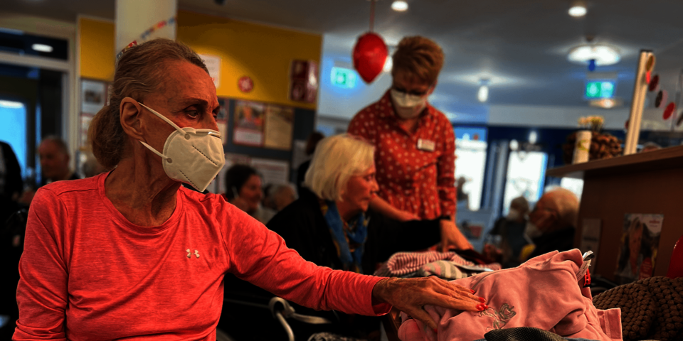 Eine ältere Dame wählt zwischen Kleidungsstücken