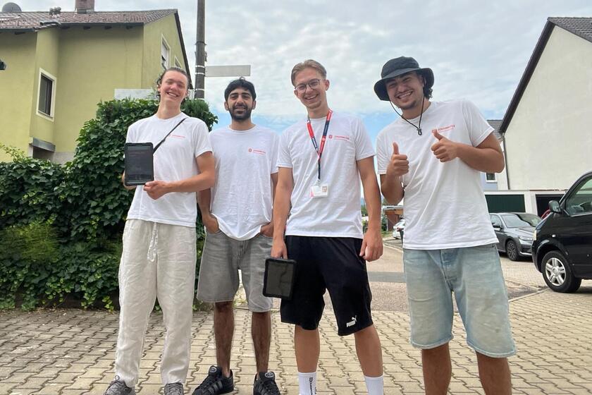 Vier junge Männer stehen nebeneinander und freuen sich auf die gemeinsame Zusammenarbeit als Wesserwerber um neue Fördermitglieder zu finden.  