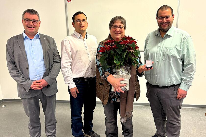 Christine Zeitler (langjährige Mitarbeiterin der Johanniter) erhält zur Verabschiedung einen Blumenstrauß und eine Gedenkmünze.