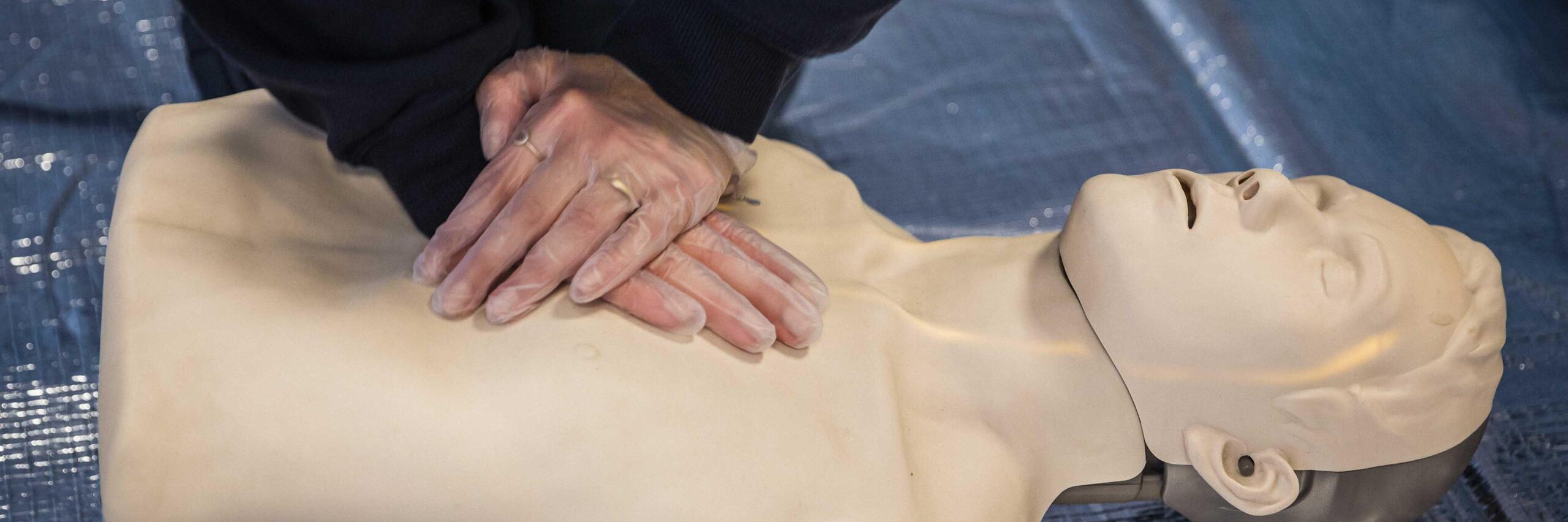 Herzdruckmassage bei einer Puppe beim Kurs