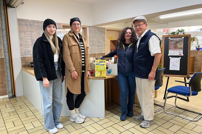 Zu sehen sind von links nach rechts Theresa Kriechenbauer (Stellvertretende Einrichtungsleitung der Johanniter-Kinderkrippe),  Marie Barone (Einrichtungsleitung der Johanniter-Kinderkrippe), Diana Hermann (Mitglied der Tafel), Reiner Sindesberger (Mitglied der Tafel) und der gespendete Korb