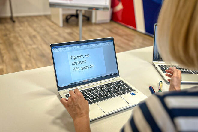 Eine Frau lernt Deutsch auf einem Laptop.