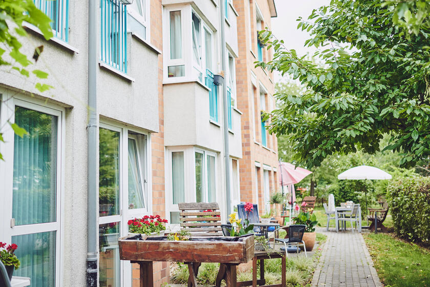 Außenansicht mit Sitzgelegenheiten und Hochbeeten am Johanniter-Stift Meerbusch
