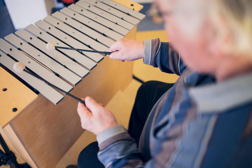 Eine Bewohnerin spielt ein Holzinstrument