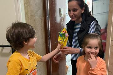 Ein Junge, ein Mädchen und deren Mutter mit dem Muttertagsgeschenk