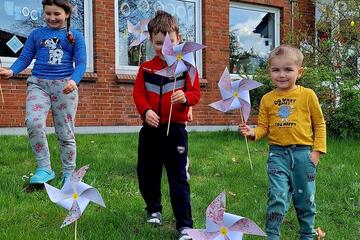 Drei Kinder mit ihren Windrädern