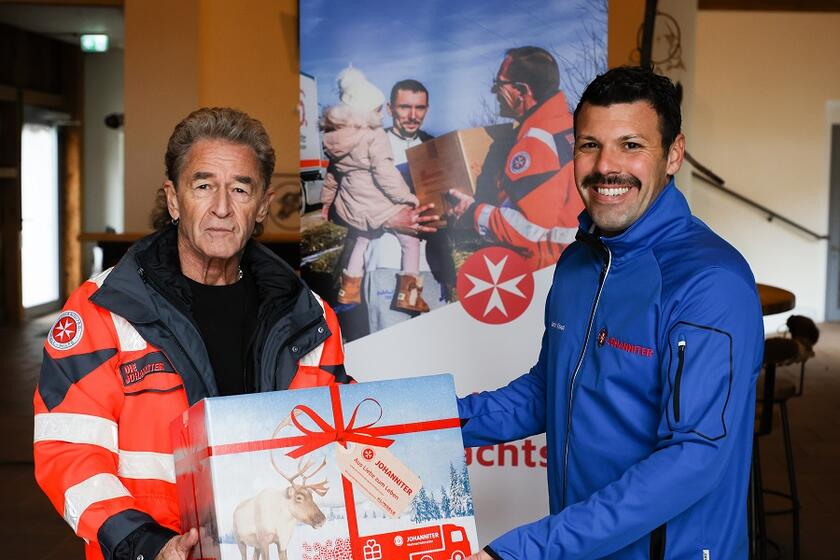 Peter Maffay übergibt sein Weihnachtstrucker-Packet symbolisch an Projektleiter Ulrich Kraus.