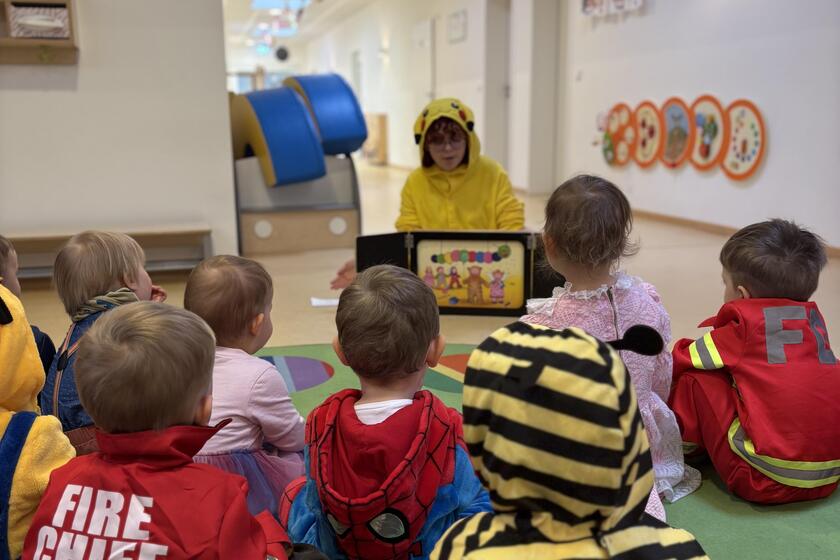 Die Kinder schauen sich gemeinsam das Bilderbuchkino an.