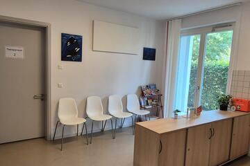 Wartebereich der Praxis mit Stühlen und Tresen