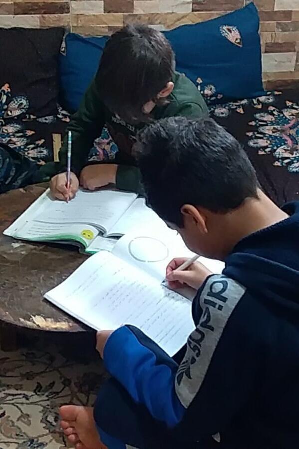 Ein Junge macht Hausaufgaben am Wohnzimmertisch