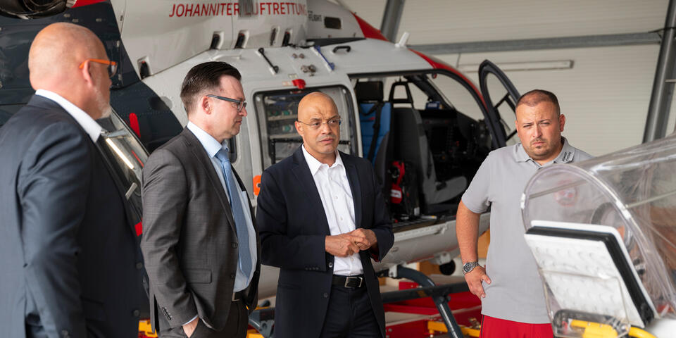 Der Abteilungsleiter Gesundheit des Hessischen Ministeriums für Soziales und Integration, Stefan Sydow, mit Gesprächspartnern aus der Johanniter Luftrettung.