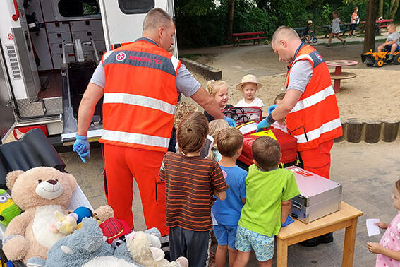 Maik Berger und Rene Maaß, Notfallsanitäter der Johanniter-Rettungswache Alt Käbelich, zeigen den Kindern der Johanniter-Kita Gänseblümchen Erste Hilfe an ihren Kuscheltieren.