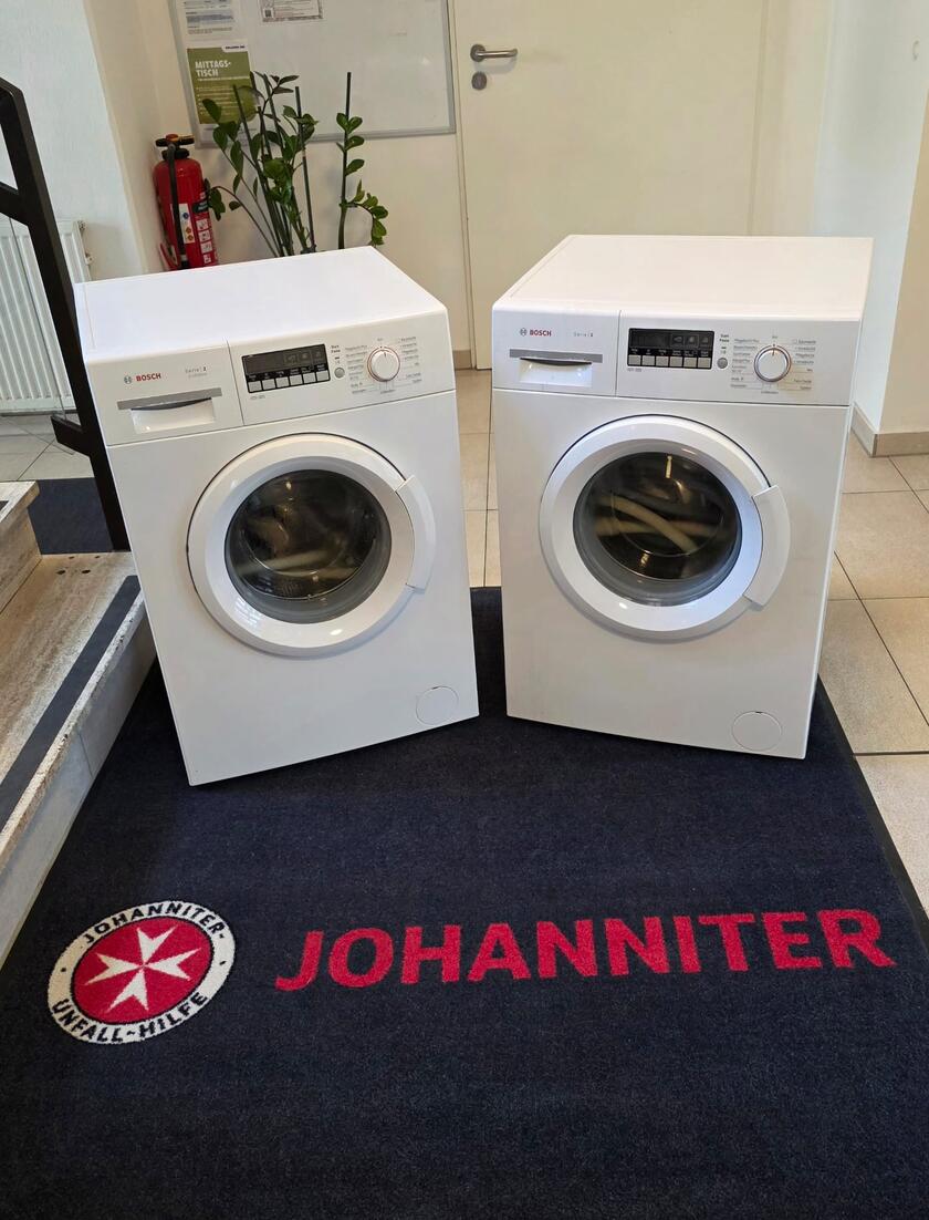Zwei Waschmaschinen auf dem Johanniterteppich