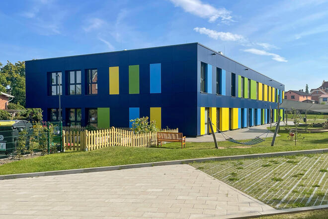 Johanniter-Kita Seehüpfer in Malente: Zu sehen ist das blaue Gebäude der Kita mit einem Teil des Außengeländes.