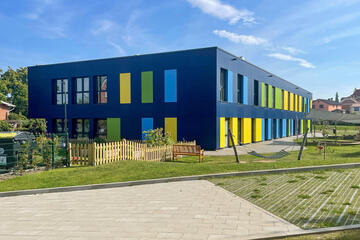 Johanniter-Kita Seehüpfer in Malente: Zu sehen ist das blaue Gebäude der Kita mit einem Teil des Außengeländes.