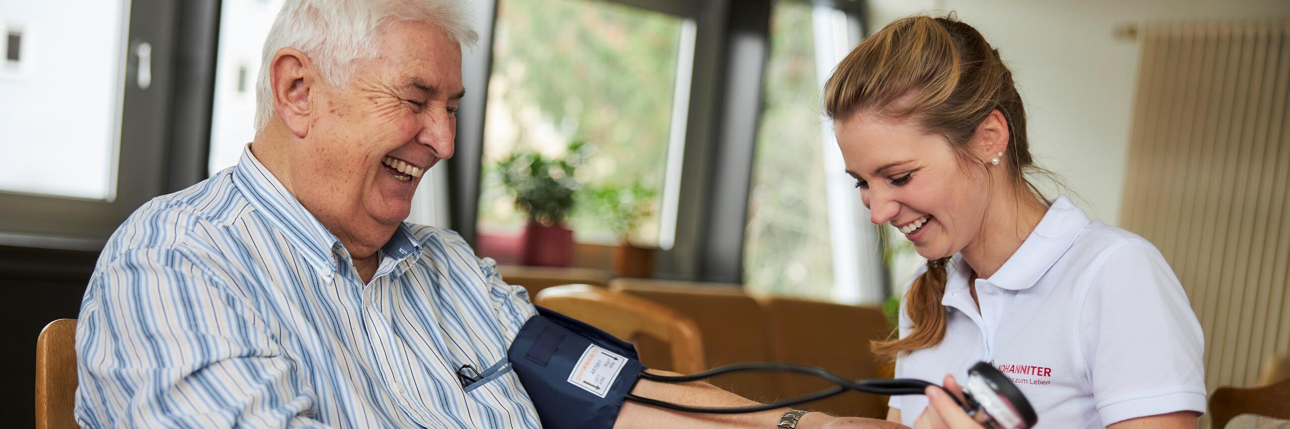 Mitarbeiterin des Ambulanten Pflegedienstes beim Blutdruckmessen 