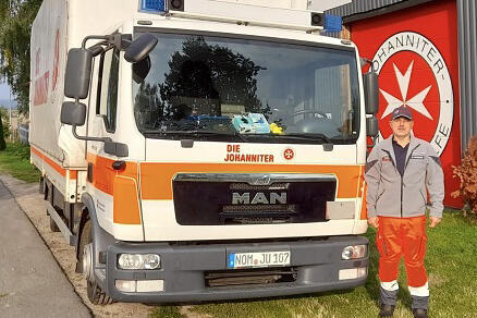 Ein Mann steht vor einem LKW