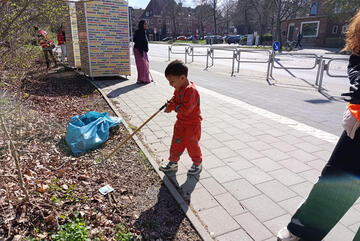 Ein Junge aus der LUK hilft den Erwachsenen beim Müllsammeln.