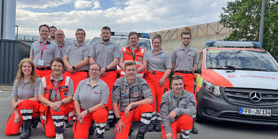 Johanniter neben einem Einsatzwagen