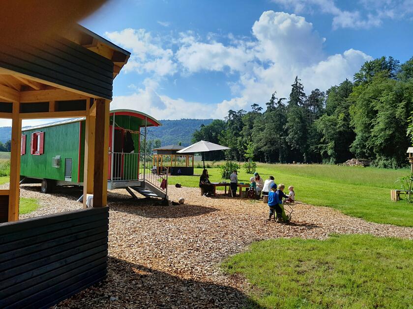 Der Unterstand des Waldkindergartens als Zirkuswagen auf eine grünen Wiese