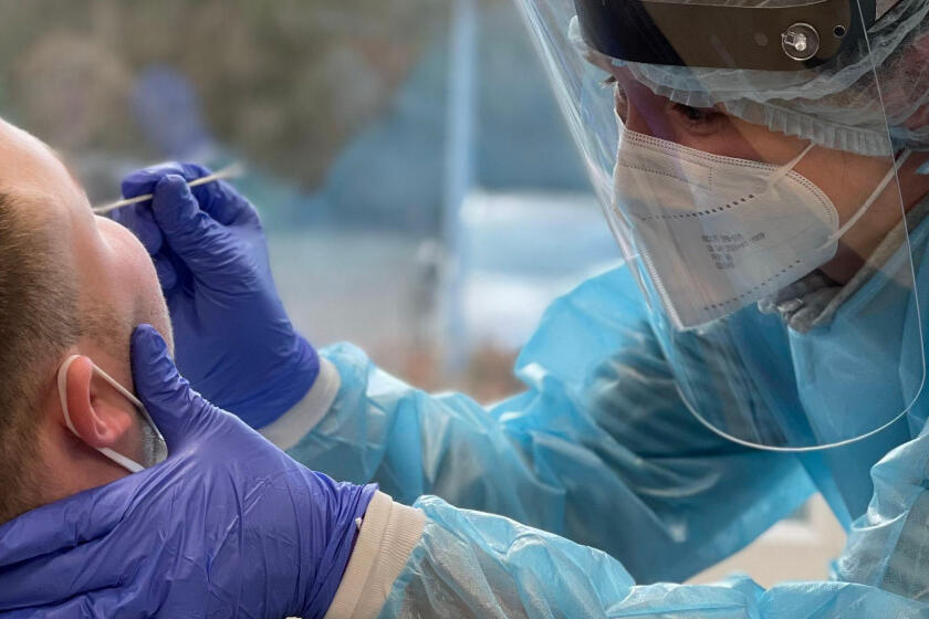 Eine Mitarbeiterin der Johanniter-Unfall-Hilfe macht einen Abstrich für einen Corona-Test bei einem Patienten.