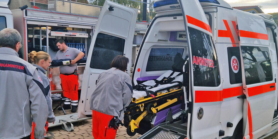 Ein Krankentransportwagen mit offenen Hecktüren und einer Trage