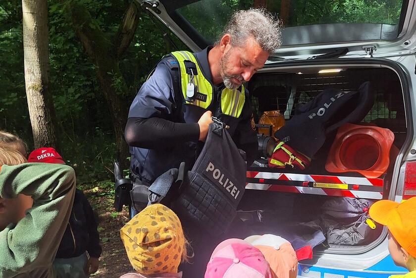 Die Kinder blicken gespannt auf die Ausrüstung der Polizei.